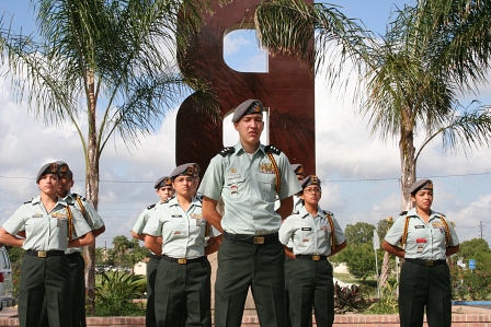 Filmausschnitt aus "Inside America": High-School-Schüler in Militäruniformen stehen im Freien in der Sonne patriotisch stramm.